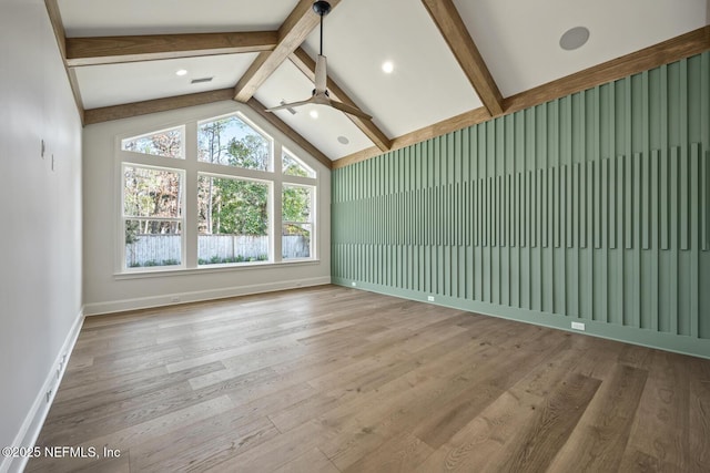 unfurnished living room with vaulted ceiling with beams and wood-type flooring