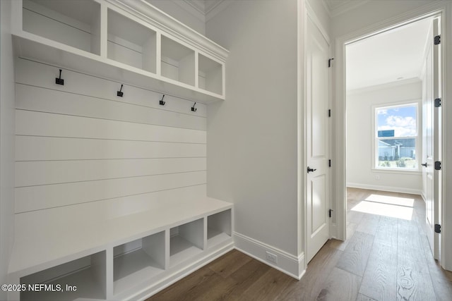 mudroom with ornamental molding and hardwood / wood-style floors