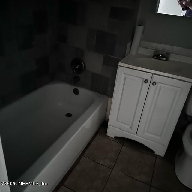 bathroom with vanity, toilet, tile patterned flooring, and a bathtub