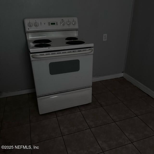 kitchen with dark tile patterned floors and white electric range oven