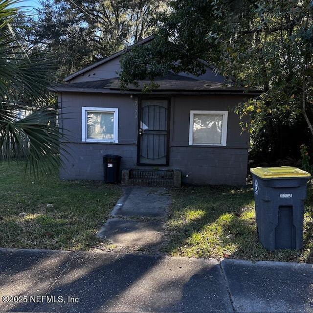 bungalow-style home with a front lawn