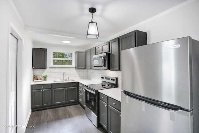 kitchen featuring appliances with stainless steel finishes, decorative light fixtures, sink, and decorative backsplash