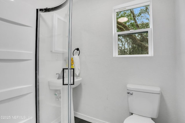 bathroom featuring walk in shower and toilet