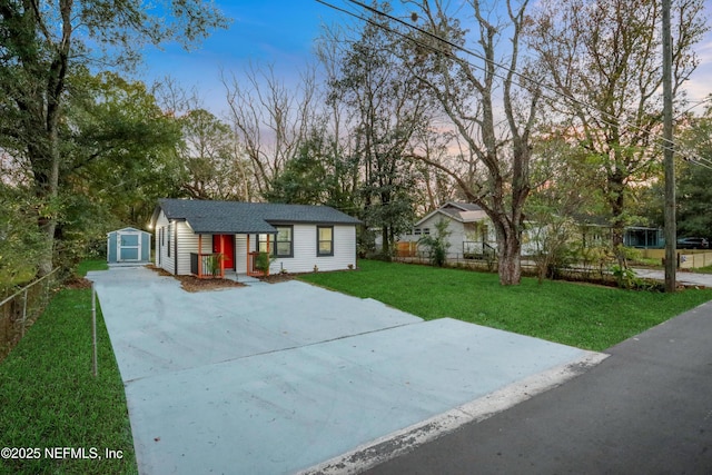 view of front facade featuring a lawn and a storage shed