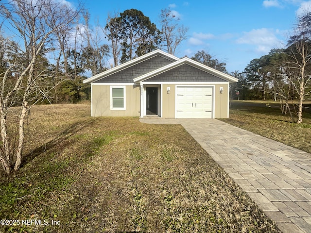 view of front of home with a garage and a front lawn