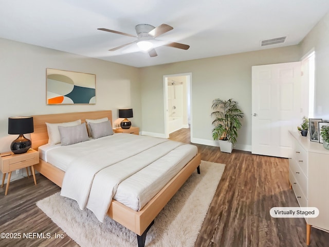 bedroom featuring ensuite bathroom, dark wood-type flooring, and ceiling fan