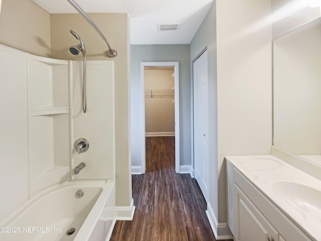 bathroom with vanity, hardwood / wood-style floors, a textured ceiling, and shower / bath combination