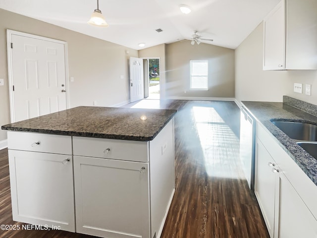 kitchen featuring white cabinetry, dark hardwood / wood-style flooring, decorative light fixtures, and vaulted ceiling