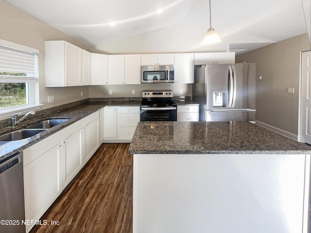 kitchen with sink, white cabinetry, vaulted ceiling, hanging light fixtures, and appliances with stainless steel finishes