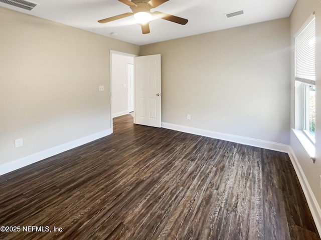 empty room featuring dark wood-type flooring and ceiling fan