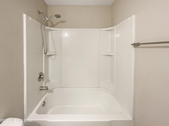 bathroom featuring shower / bathtub combination and toilet