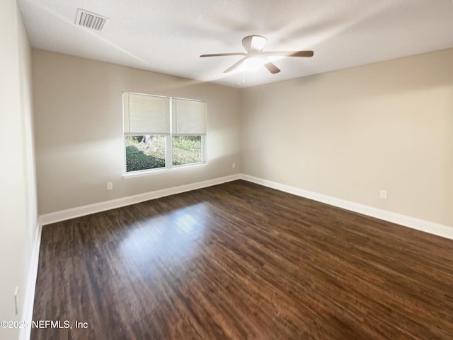 spare room featuring dark wood-type flooring and ceiling fan