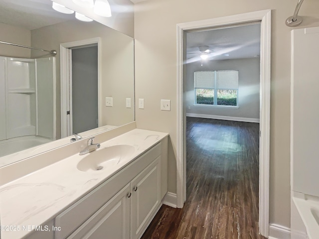 bathroom with vanity, hardwood / wood-style flooring, and washtub / shower combination