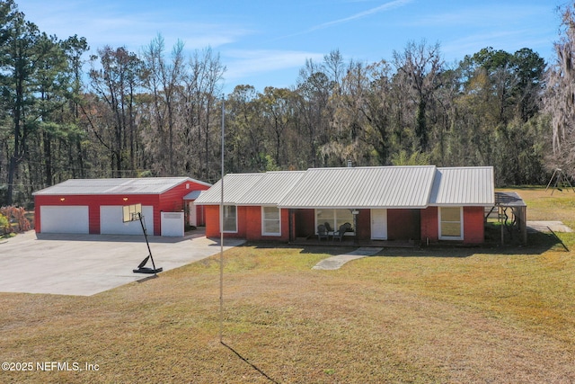 ranch-style house featuring an outbuilding, a garage, covered porch, and a front lawn