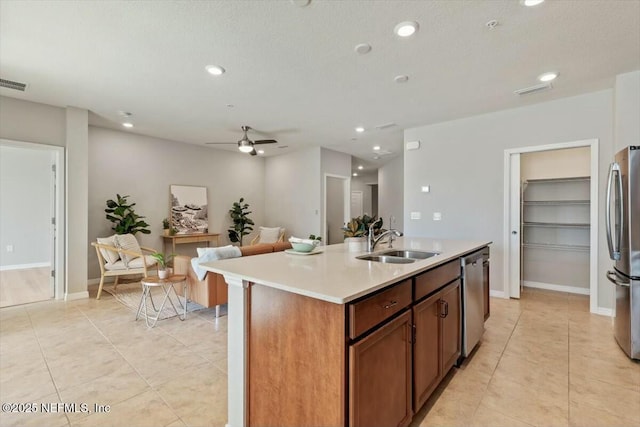 kitchen featuring stainless steel appliances, sink, a kitchen island with sink, and light tile patterned floors