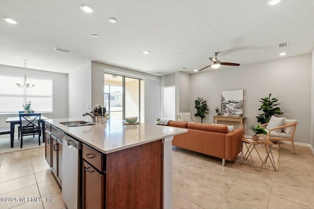 kitchen featuring sink, decorative light fixtures, stainless steel dishwasher, plenty of natural light, and an island with sink