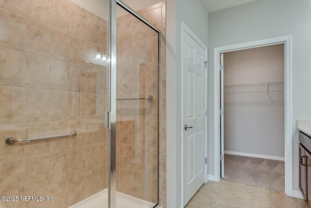 bathroom with vanity, a shower with shower door, and tile patterned floors