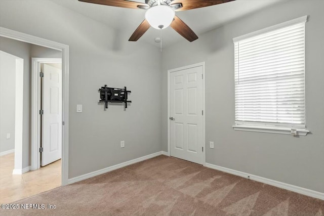 unfurnished room with light carpet and ceiling fan