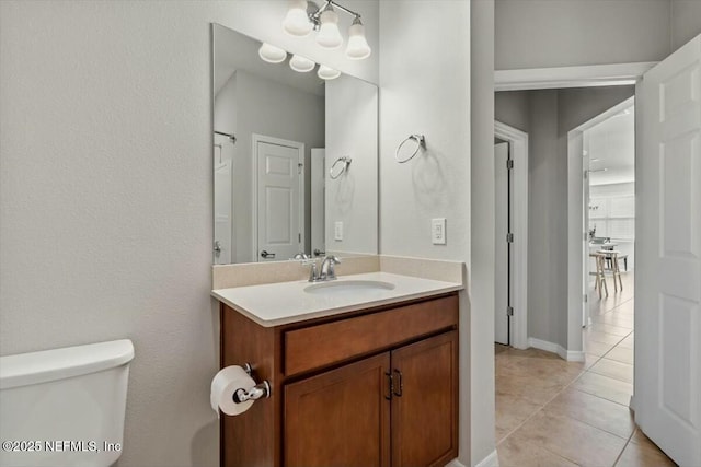 bathroom with tile patterned flooring, vanity, and toilet