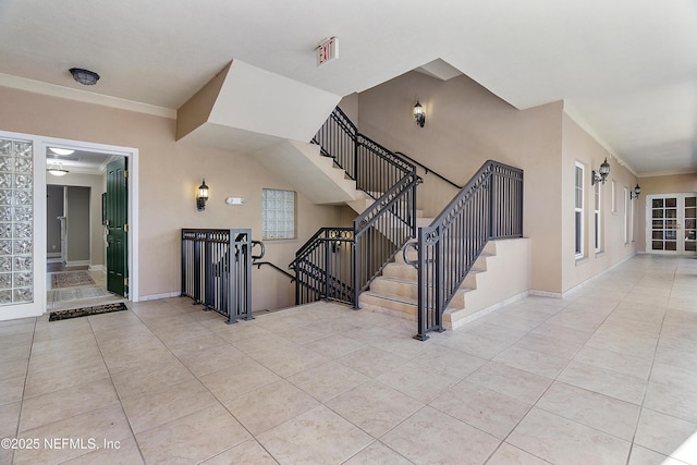 stairs featuring tile patterned flooring and crown molding