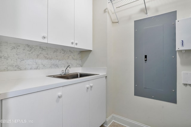 kitchen with white cabinetry, electric panel, sink, and decorative backsplash