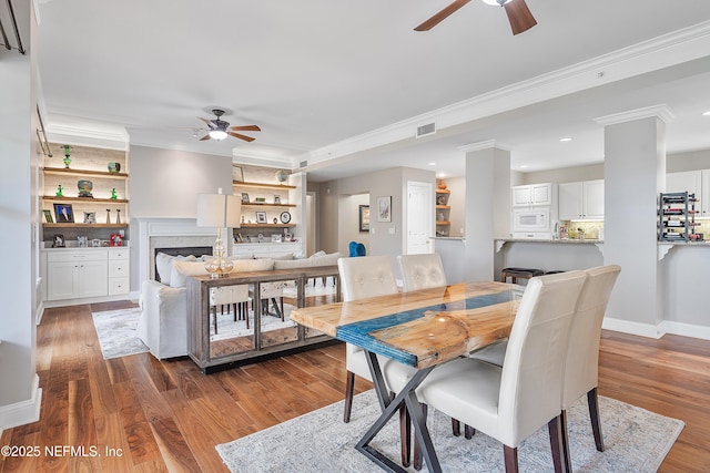 dining area featuring crown molding, dark hardwood / wood-style floors, and ceiling fan