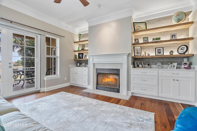 living room featuring a tile fireplace, ornamental molding, ceiling fan, and dark hardwood / wood-style flooring