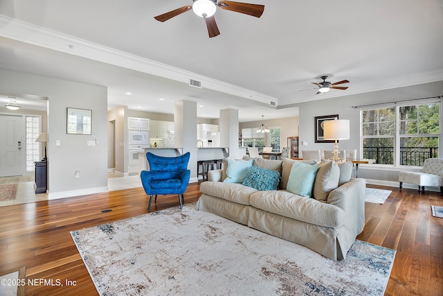 living room featuring crown molding, dark hardwood / wood-style floors, and a wealth of natural light