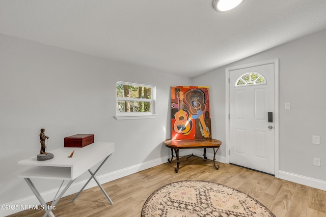 entrance foyer with lofted ceiling, hardwood / wood-style floors, and a wealth of natural light