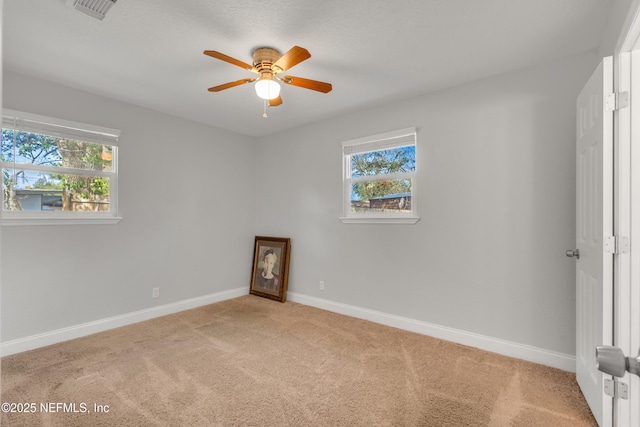 carpeted spare room featuring ceiling fan