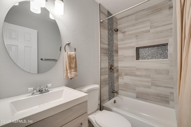 full bathroom with tiled shower / bath, vanity, and toilet