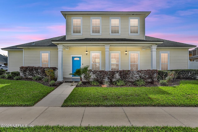 view of front of house with a yard and a porch