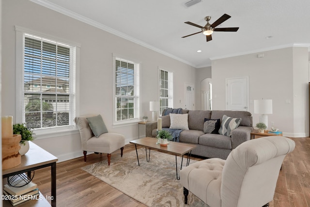 living room with light hardwood / wood-style flooring, ornamental molding, and ceiling fan