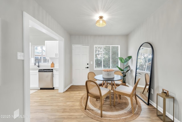 dining area featuring sink and light hardwood / wood-style floors