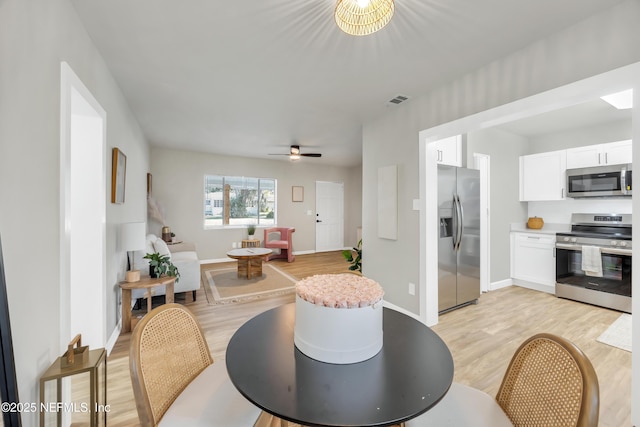 dining space with light hardwood / wood-style flooring and ceiling fan