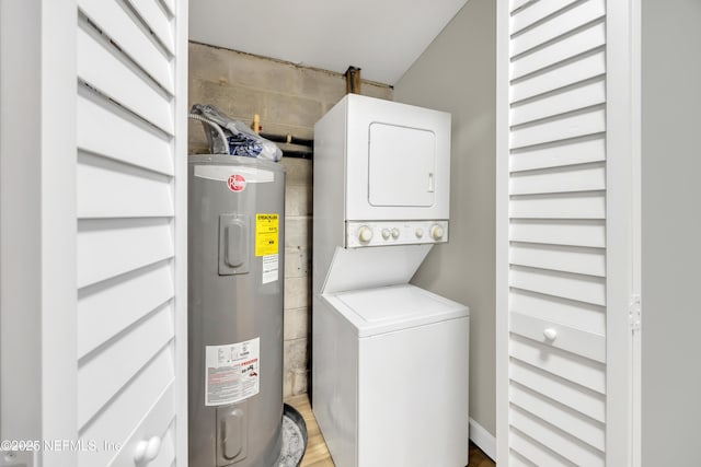 laundry room with stacked washer / drying machine and electric water heater