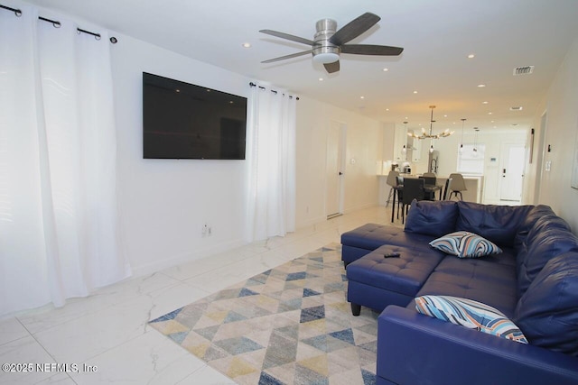 living room with ceiling fan with notable chandelier