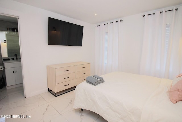 bedroom featuring ensuite bathroom and sink