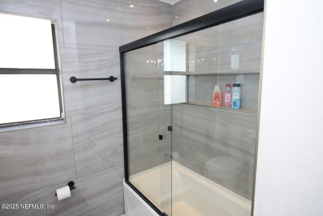 bathroom with combined bath / shower with glass door