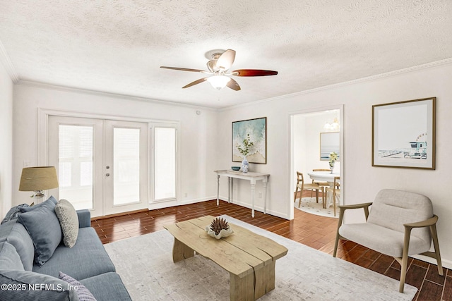 living room with ceiling fan, ornamental molding, french doors, and a textured ceiling