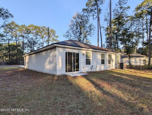 back of house featuring a yard and central AC unit