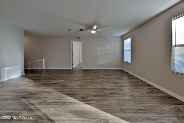 unfurnished room featuring ceiling fan, dark hardwood / wood-style floors, and a textured ceiling