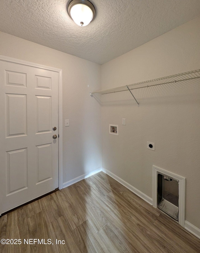 clothes washing area with hardwood / wood-style flooring, hookup for an electric dryer, washer hookup, and a textured ceiling