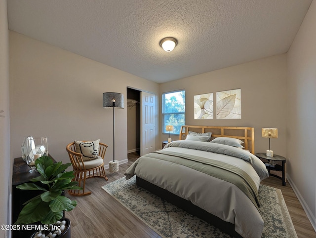 bedroom with hardwood / wood-style flooring, a textured ceiling, and a closet