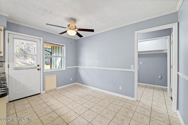 foyer with crown molding, ceiling fan, a textured ceiling, and light tile patterned floors