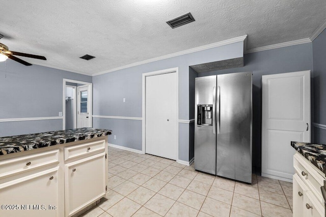 kitchen featuring ceiling fan, ornamental molding, stainless steel fridge, and white cabinets