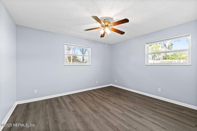 empty room featuring ceiling fan, dark wood-type flooring, and a textured ceiling