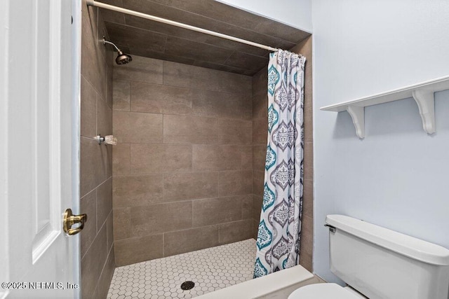 bathroom featuring curtained shower and toilet