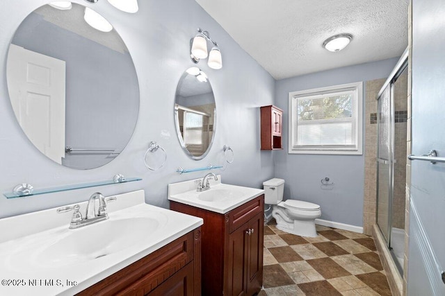 bathroom featuring vanity, an enclosed shower, a textured ceiling, and toilet