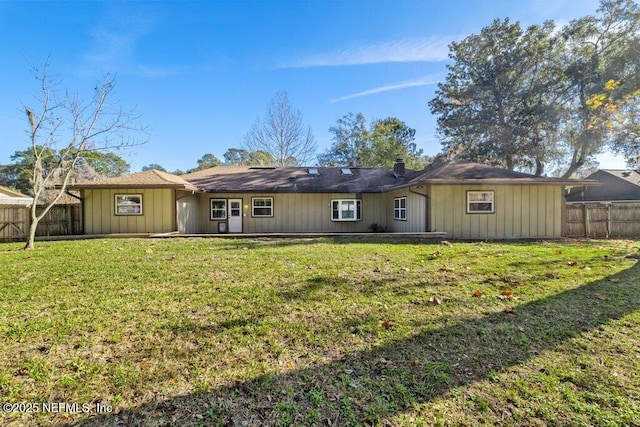 rear view of property with a lawn